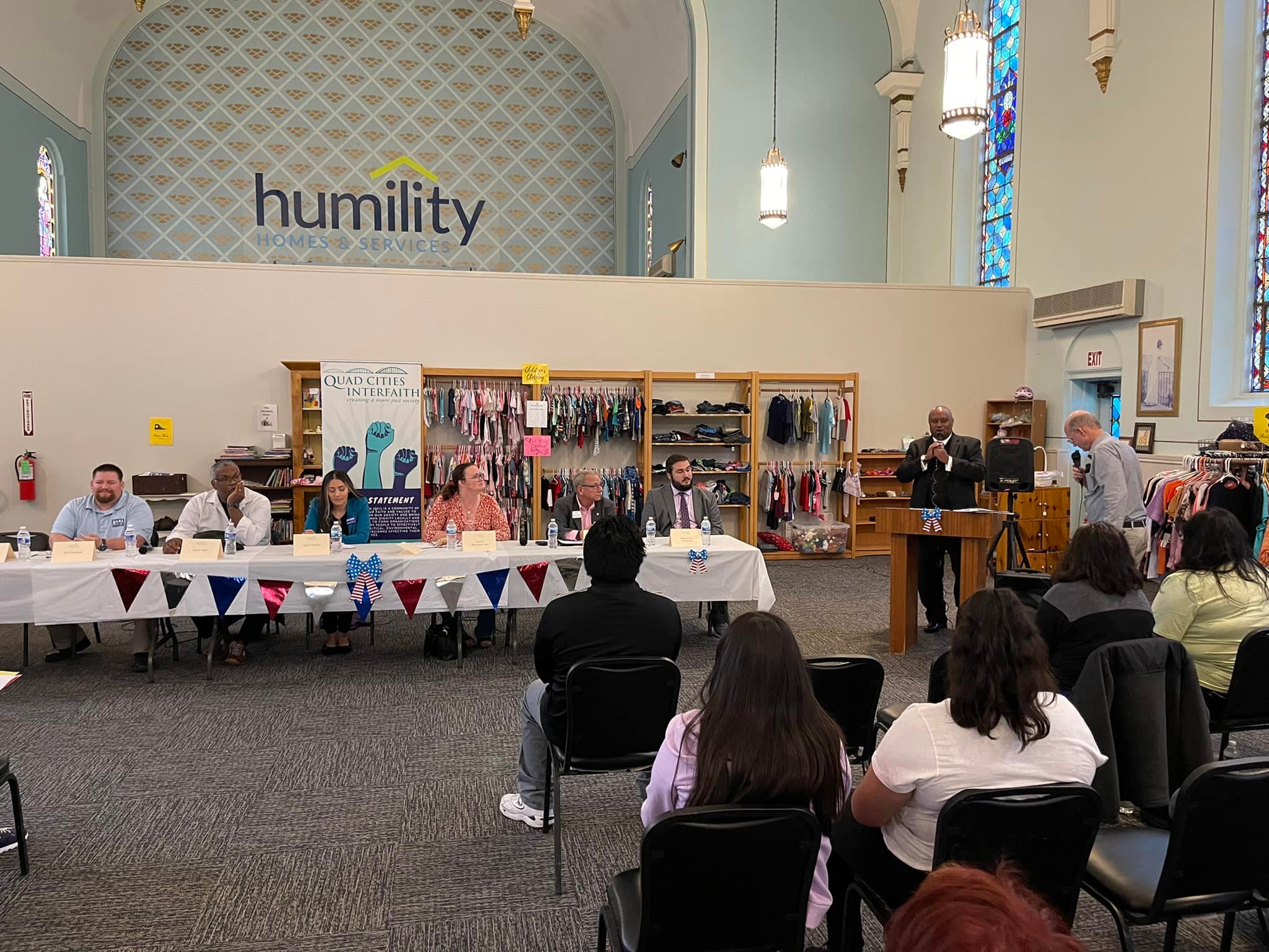 People at a table holding a town hall meeting at Humility Homes and Services